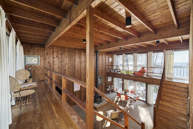 hallway with wood walls, wood ceiling, hardwood / wood-style flooring, and beamed ceiling