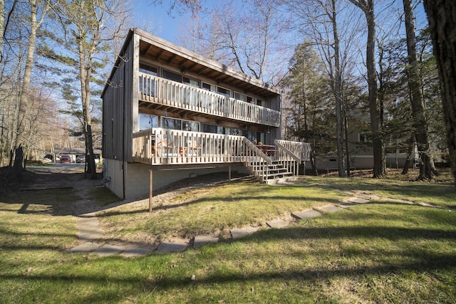 rear view of property with a yard, a deck, and stairway