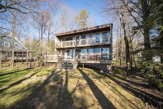rear view of house with a wooden deck and a yard