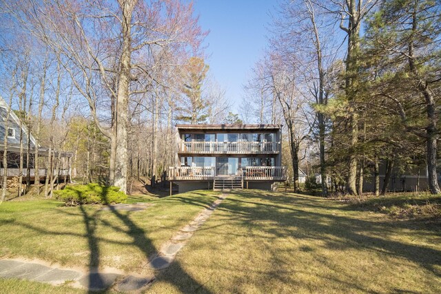 back of house featuring a lawn and a wooden deck