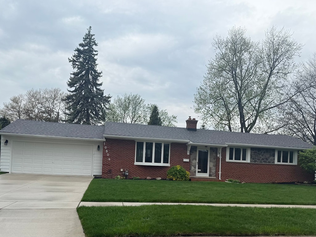 ranch-style house with brick siding, driveway, a chimney, and a garage