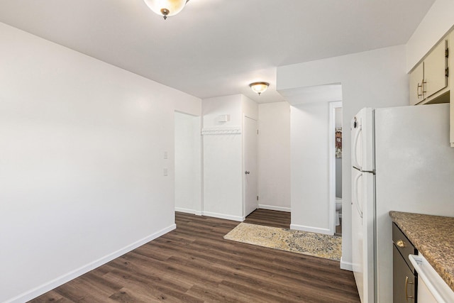 kitchen featuring freestanding refrigerator, dark wood-style floors, and baseboards