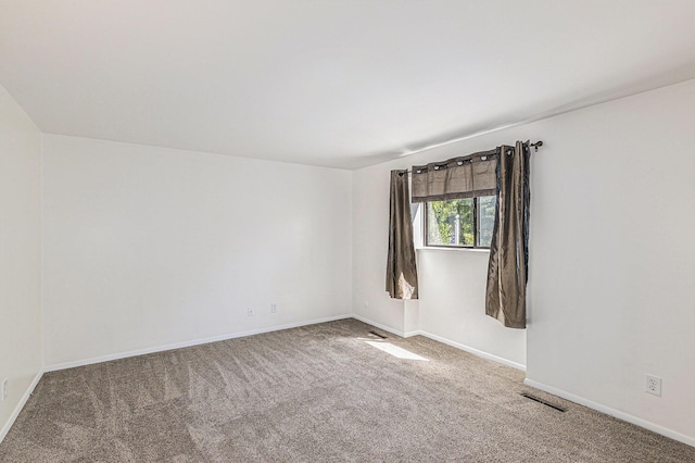 carpeted empty room featuring baseboards