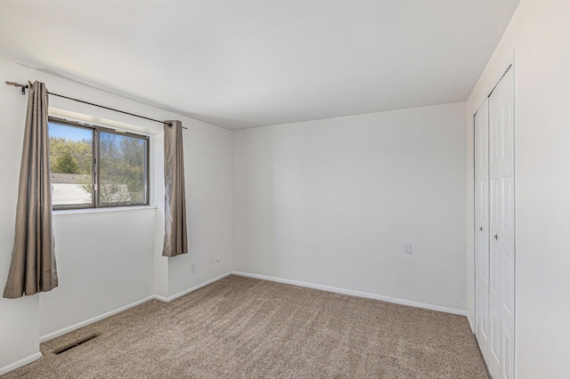 unfurnished bedroom with carpet flooring, baseboards, and a closet