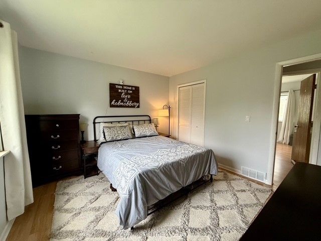 bedroom featuring visible vents, wood finished floors, and a closet