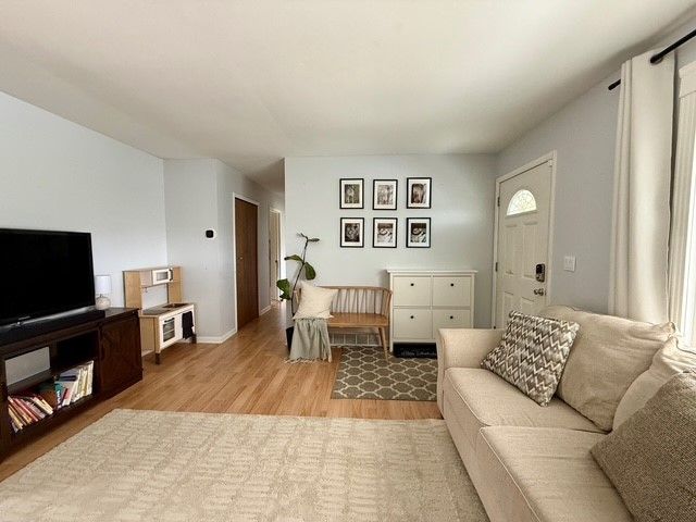 living room featuring baseboards and light wood finished floors
