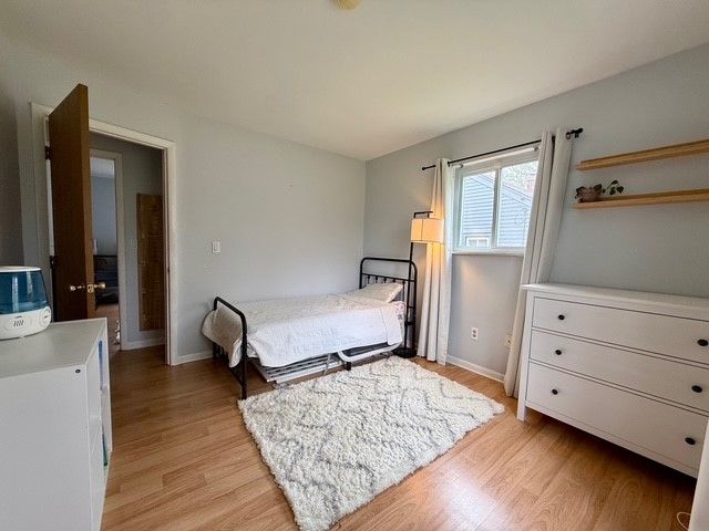 bedroom with light wood-type flooring and baseboards