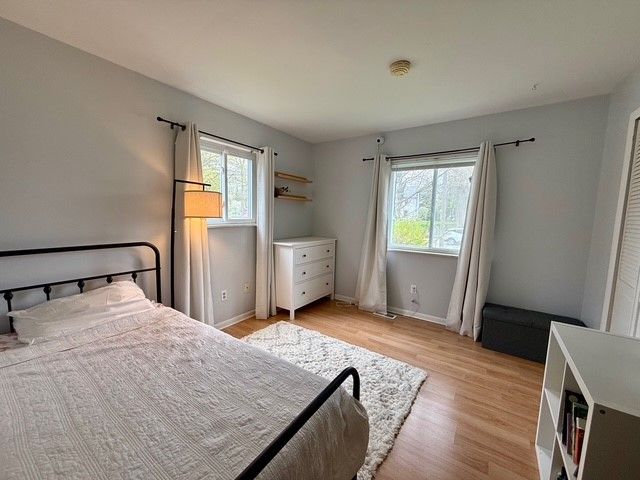 bedroom featuring baseboards, multiple windows, and light wood-style floors