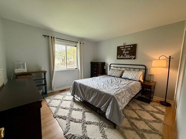 bedroom with baseboards and wood finished floors