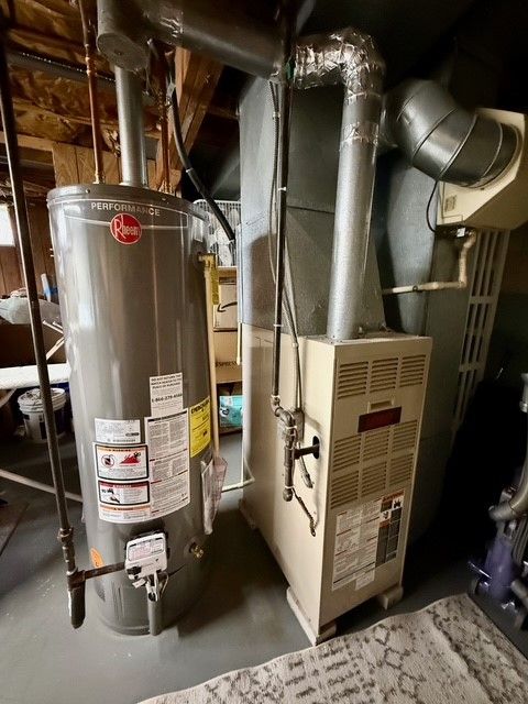 utility room featuring water heater and heating unit
