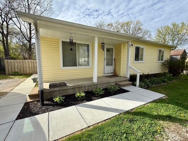 view of front of home featuring a porch and fence