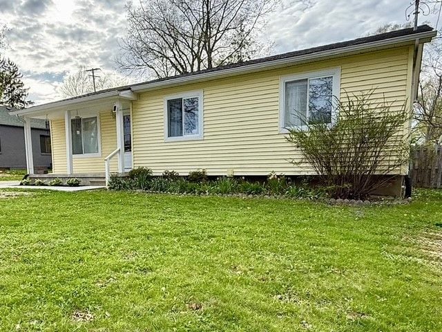 manufactured / mobile home with covered porch and a front lawn