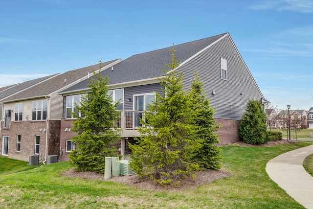2774 Polson St, Ann Arbor, MI 48105 - view of side of property featuring brick siding, a lawn, and cooling unit