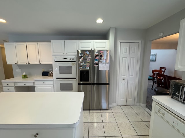kitchen with white cabinets, light tile patterned flooring, white appliances, light countertops, and recessed lighting