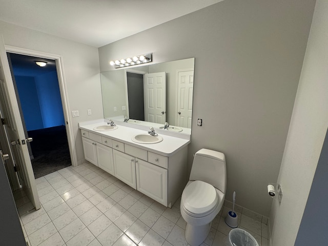 bathroom with tile patterned flooring, a sink, double vanity, and toilet