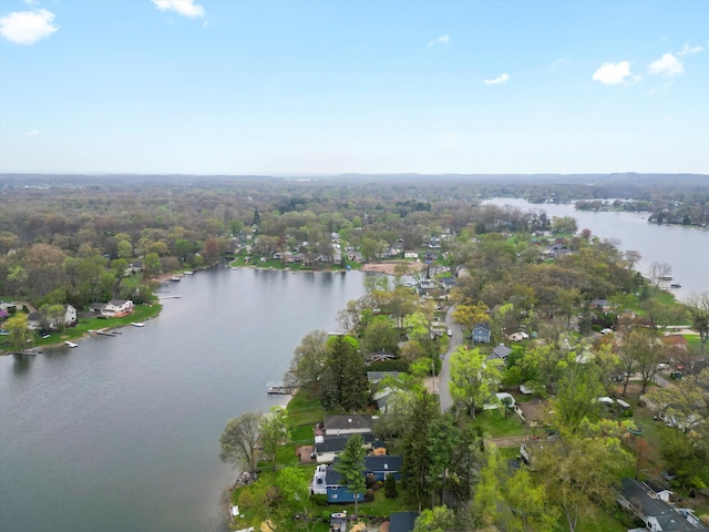 drone / aerial view featuring a water view, a residential view, and a forest view