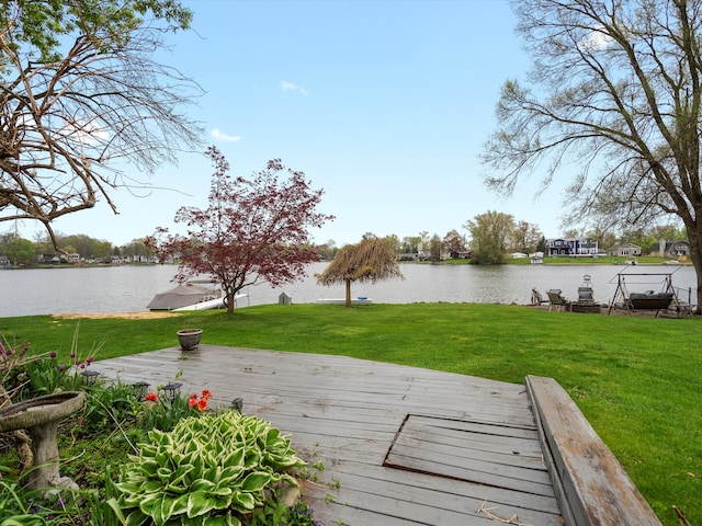 view of dock with a lawn and a deck with water view
