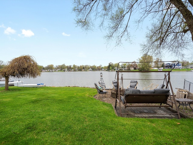 view of dock featuring a water view and a yard