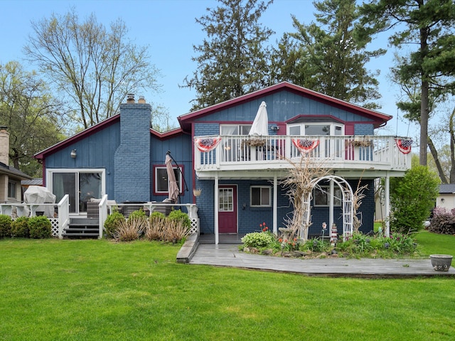 back of house featuring a lawn, a chimney, and a deck