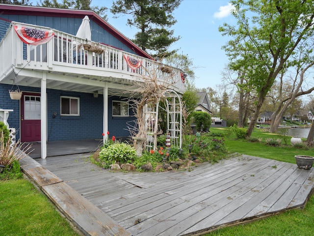 back of property featuring brick siding and a deck