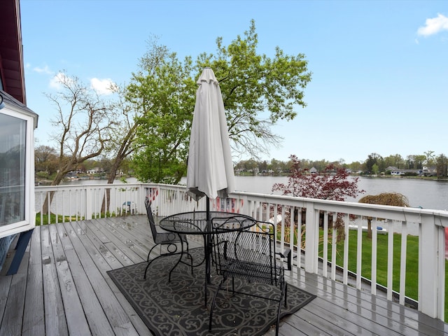 wooden deck with outdoor dining space and a water view