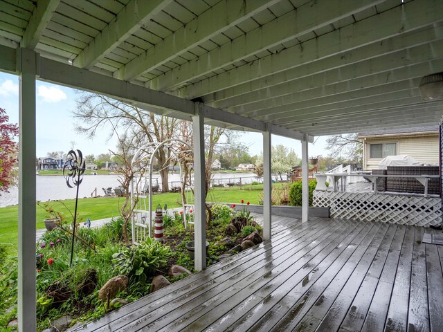 wooden deck with a lawn and a water view