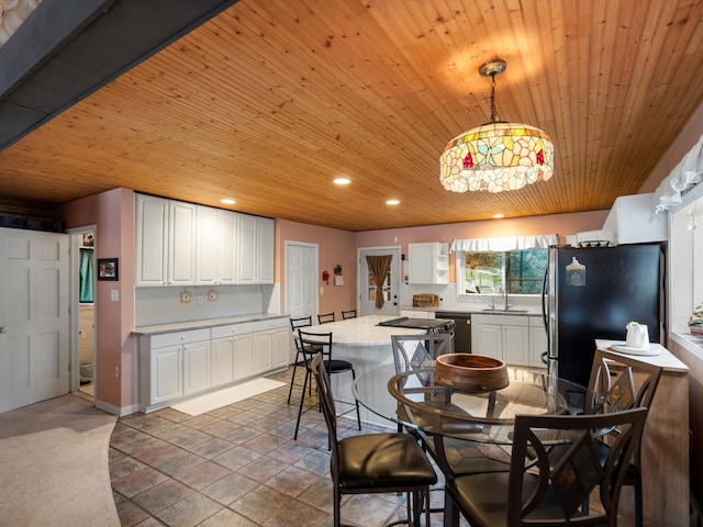 kitchen with freestanding refrigerator, a sink, white cabinets, and wooden ceiling