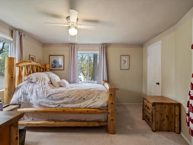 bedroom with baseboards, ceiling fan, and light colored carpet