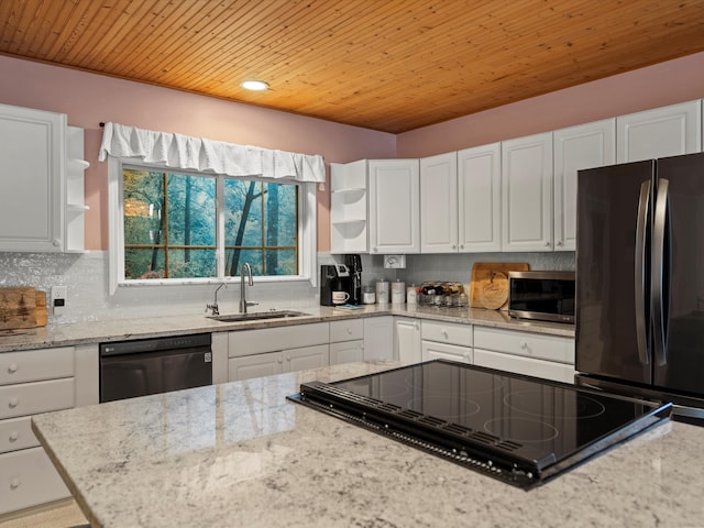 kitchen featuring open shelves, dishwasher, a sink, stainless steel microwave, and freestanding refrigerator