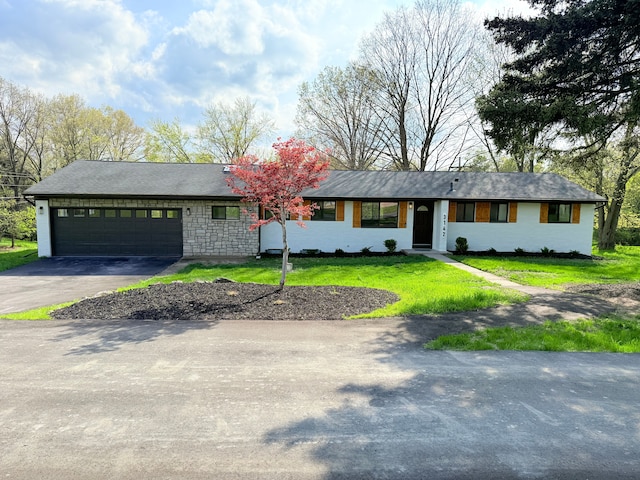 single story home with an attached garage, driveway, and a front yard