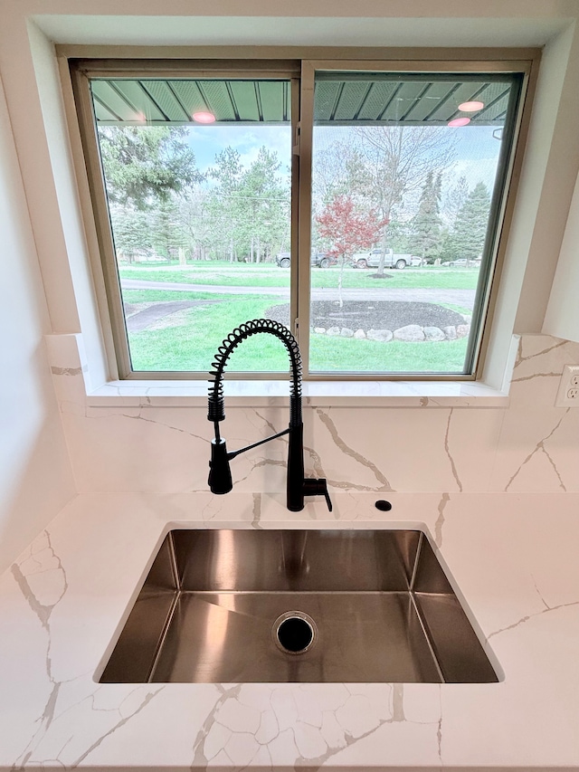 room details featuring a sink and light stone countertops