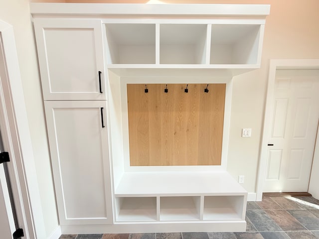 mudroom with baseboards and stone finish floor
