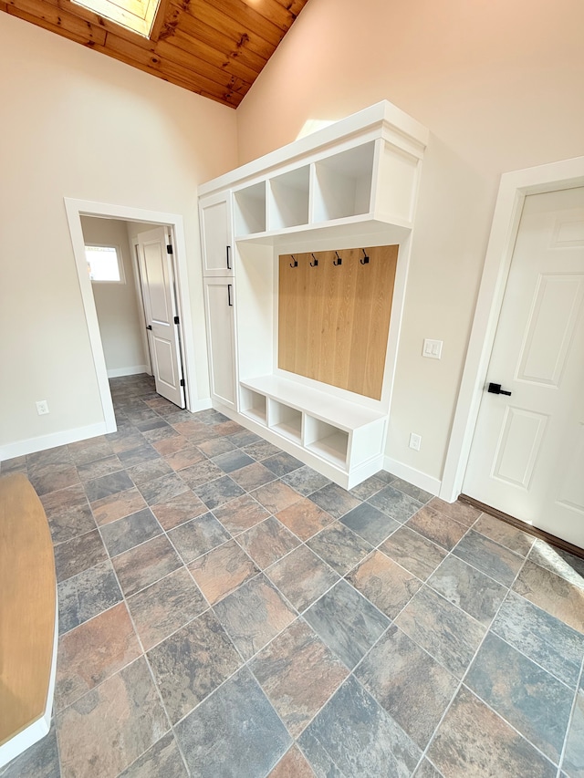 mudroom with baseboards, stone tile flooring, a skylight, and wooden ceiling