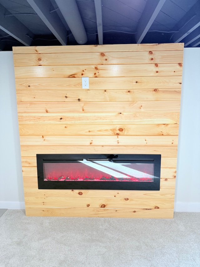 details featuring a glass covered fireplace, baseboards, and carpet flooring