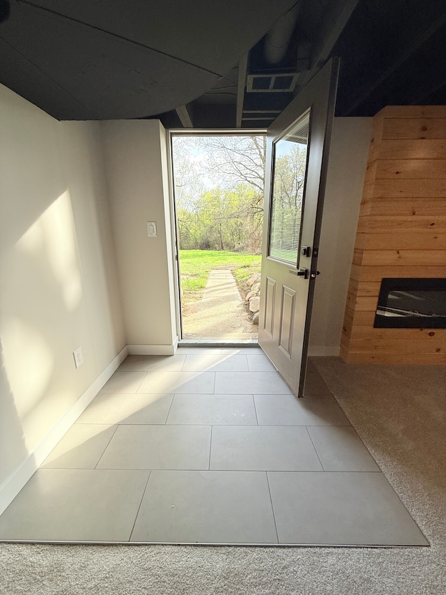 doorway to outside with baseboards and light tile patterned flooring