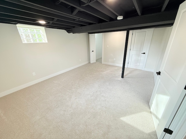 basement with baseboards and light carpet