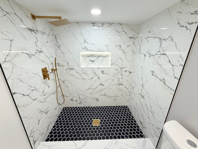 full bathroom with a marble finish shower and toilet