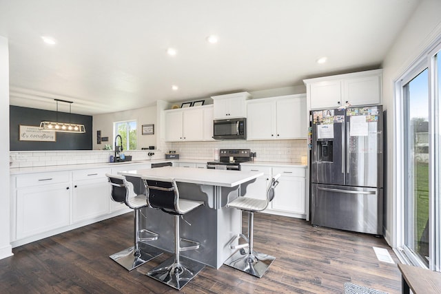 kitchen with light countertops, stainless steel appliances, plenty of natural light, and tasteful backsplash