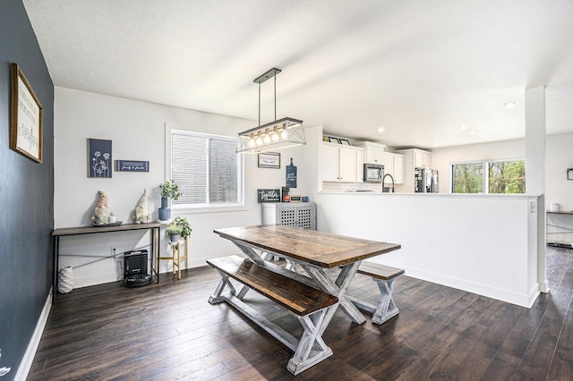 dining area featuring baseboards and dark wood-style flooring