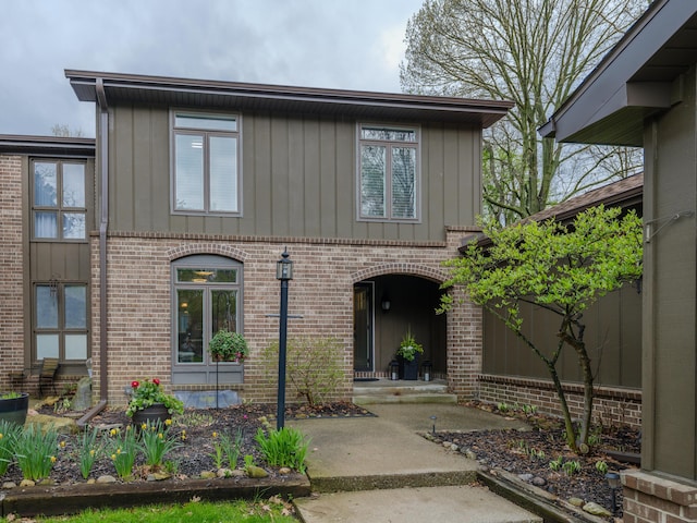 property entrance with brick siding and board and batten siding