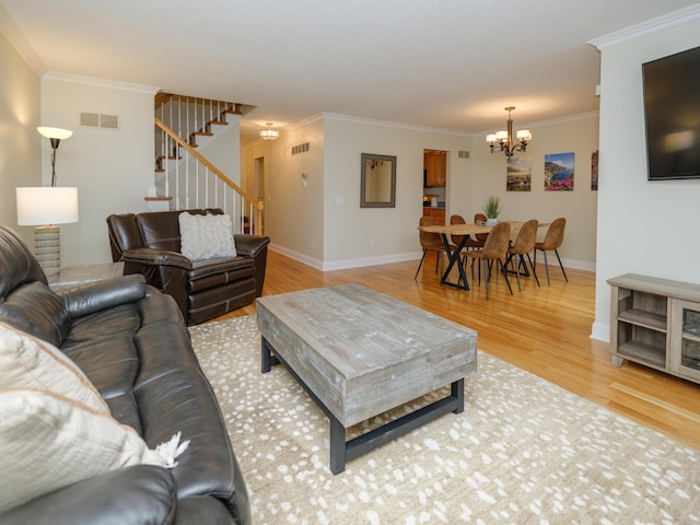 living area with crown molding, a chandelier, stairs, light wood-type flooring, and visible vents