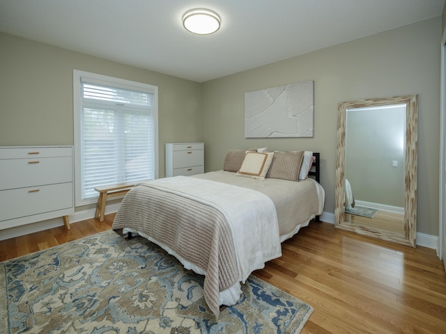 bedroom with baseboards and light wood finished floors