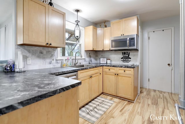 7116 Linden Ave SE, Grand Rapids, MI 49548 - kitchen featuring dark countertops, a sink, stainless steel microwave, light wood finished floors, and light brown cabinets