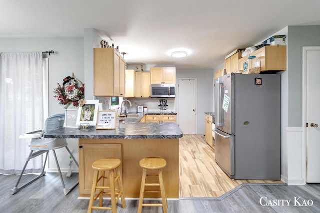 7116 Linden Ave SE, Grand Rapids, MI 49548 - kitchen with light wood-type flooring, a sink, light brown cabinetry, and stainless steel appliances