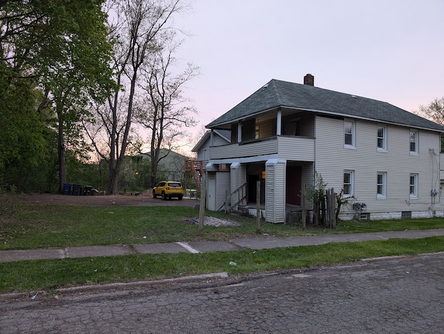 249 W Wilson Ave, Pontiac, MI 48341 - view of home's exterior featuring driveway, a chimney, roof with shingles, a lawn, and a balcony