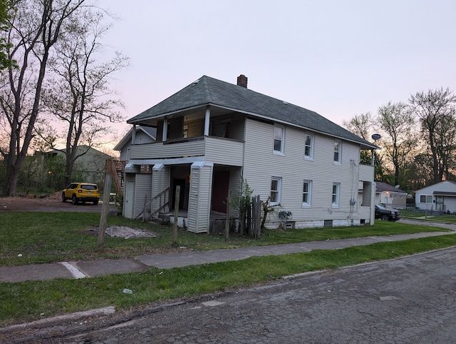 249 W Wilson Ave, Pontiac, MI 48341 - view of side of home featuring a shingled roof, a yard, a balcony, and a chimney