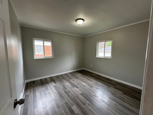 empty room with baseboards, dark wood-style floors, and ornamental molding