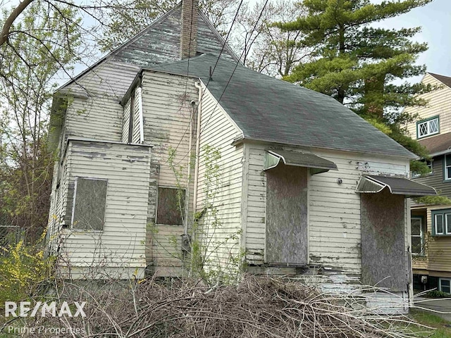 view of side of property with a shingled roof