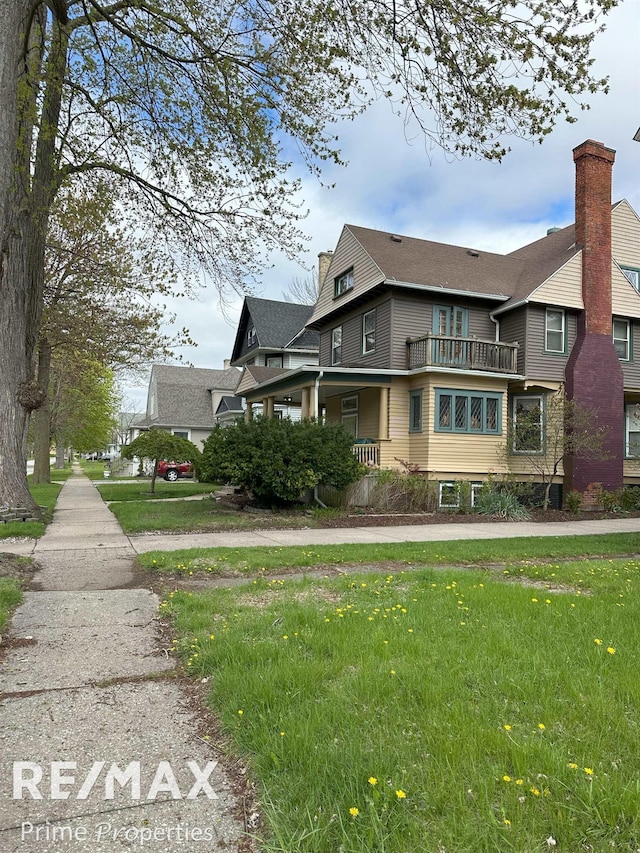 view of property exterior with a lawn and a balcony