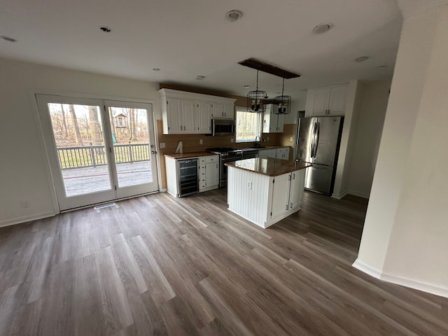 9615 Woodland Ct, Ypsilanti, MI 48197 - kitchen featuring beverage cooler, baseboards, a chandelier, white cabinets, and stainless steel appliances